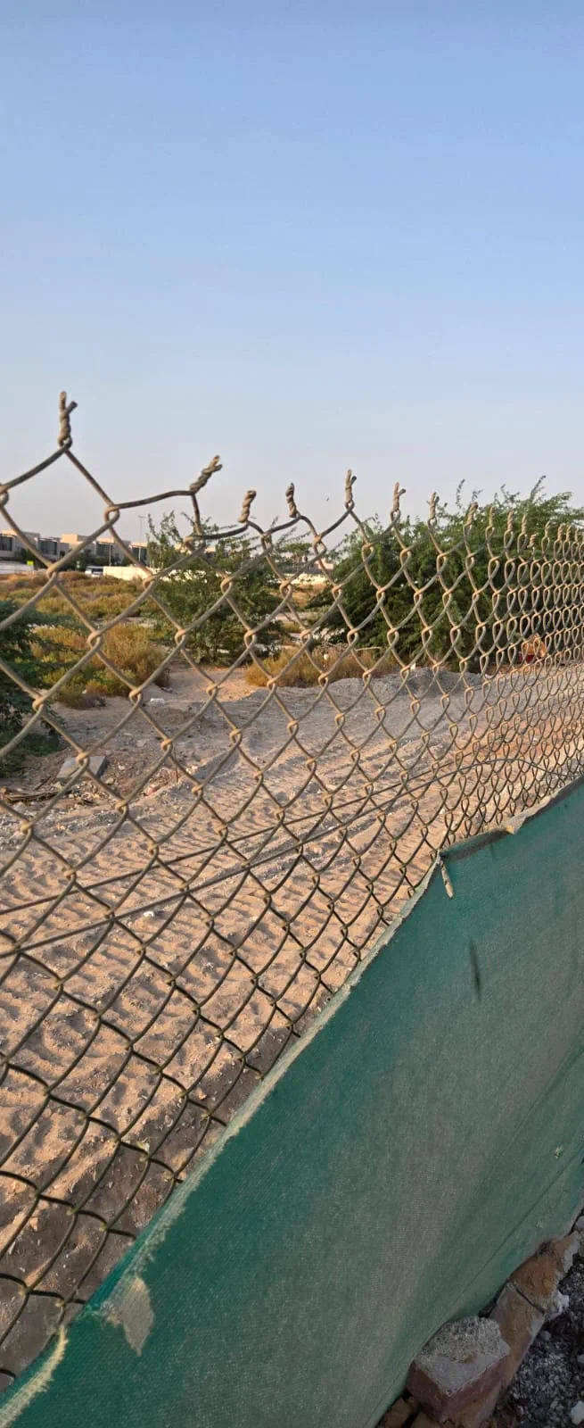 Chain link fencing installed with green privacy mesh